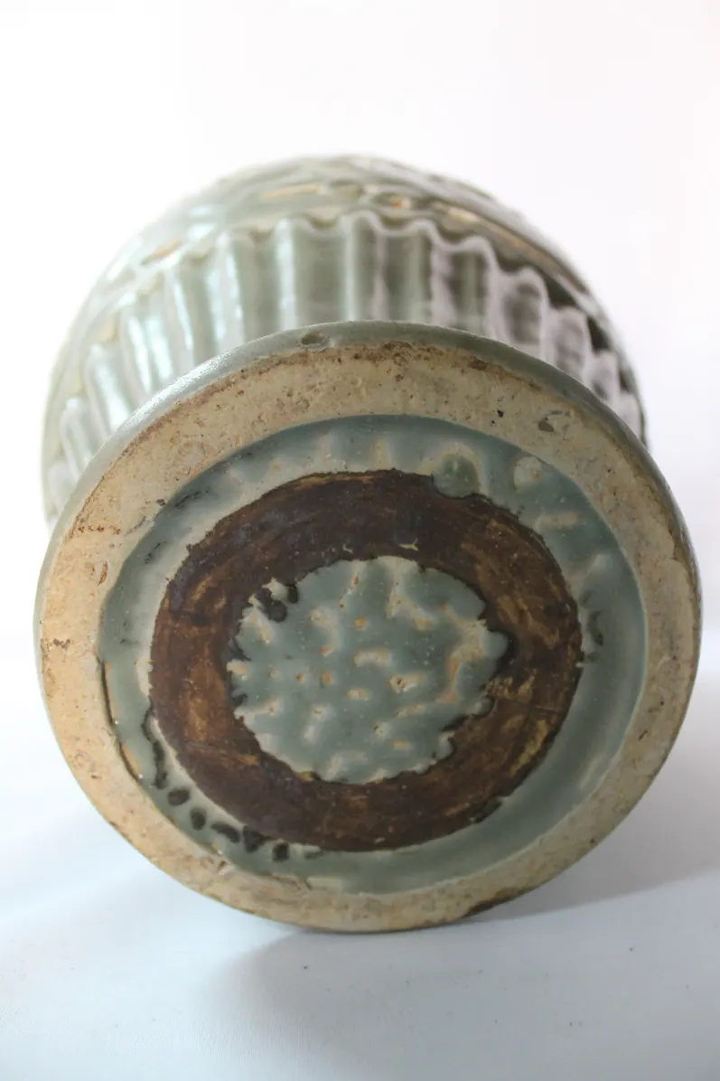 Base of the celadon vase, close-up, with a mottled rust and crackle pattern