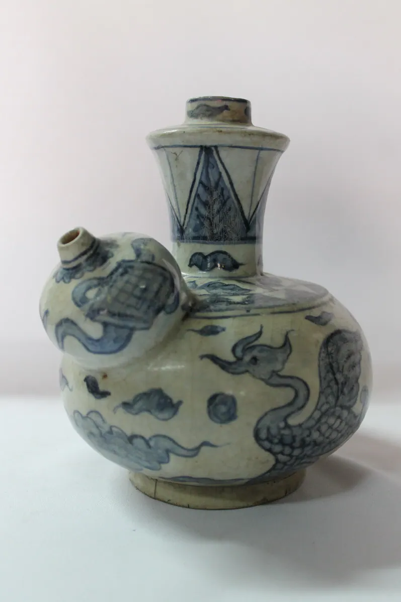 Blue and white kendi, angled view showing the phoenix head, clouds and the decorated spout