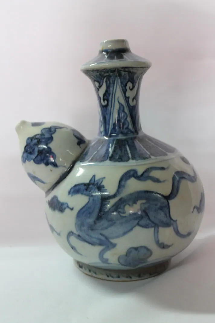 Blue and white kendi with a galloping horse among clouds on the body and the spout to the left