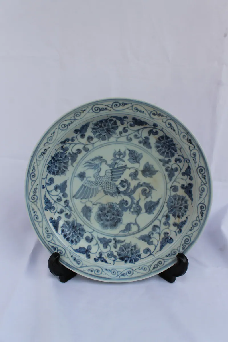 Blue and white dish on a stand with a central phoenix and peony medallion and a peony scroll border