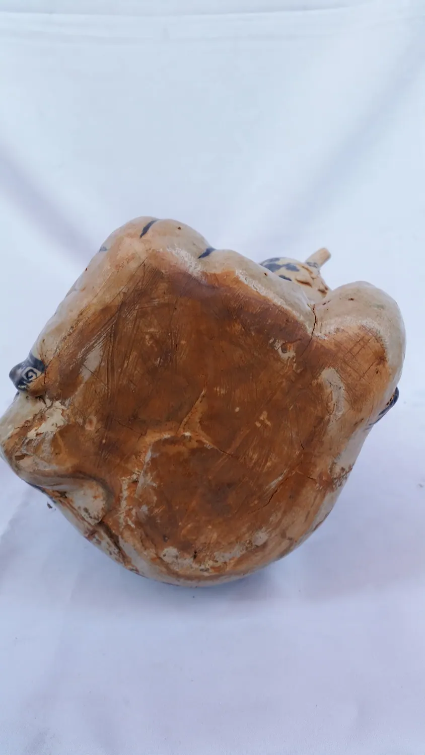 Close-up of the unglazed base showing tool marks across the reddish-brown clay