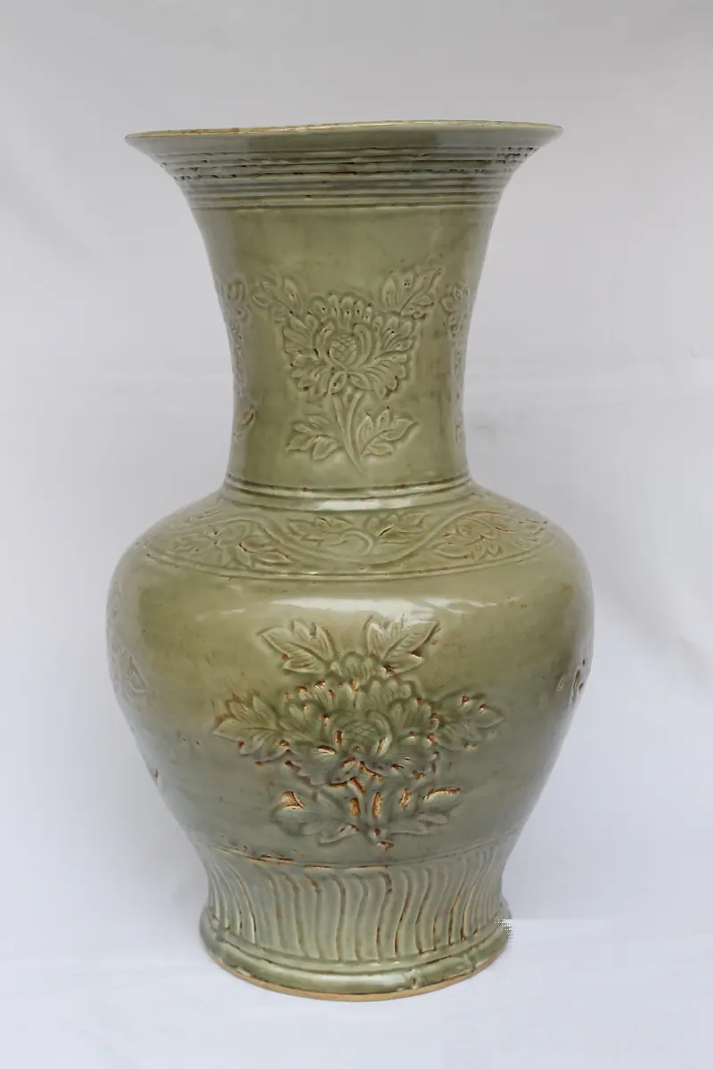 Celadon vase, front view, with a flared neck, carved peony sprays and a fluted foot