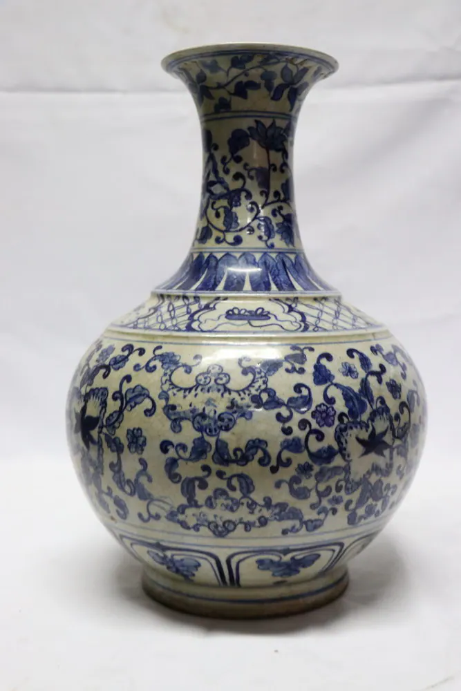 Front view of the blue and white vase with a flaring trumpet neck and dense floral scrollwork
