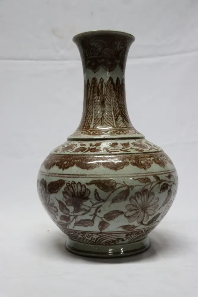 Front view of the bottle vase, its crackled grey-white glaze painted with rust-brown floral bands