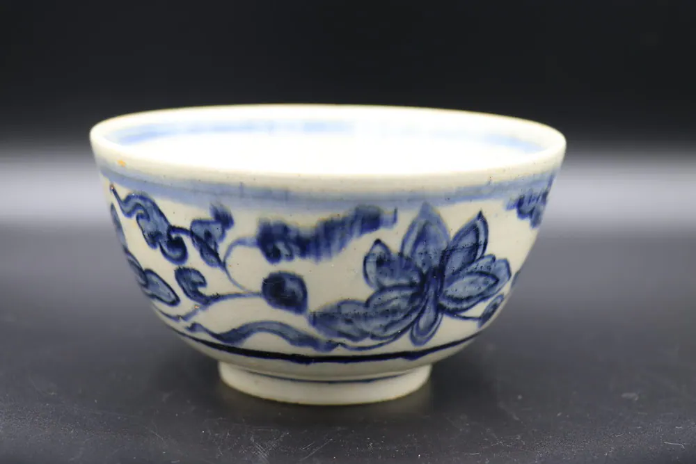 Exterior of the bowl showing a lotus blossom scroll in cobalt blue against the ivory body