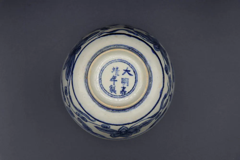 Base of the bowl with the Jiajing reign mark in a double ring, exterior lotus scroll visible around the edge