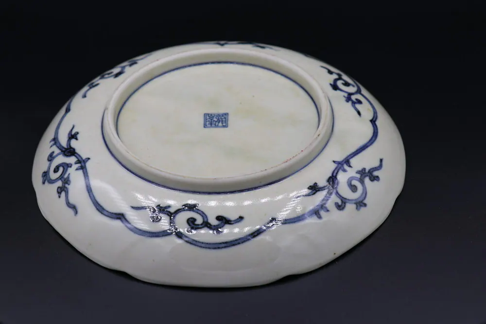 Underside of the plate showing the square base mark and a scrolling vine border on the rim
