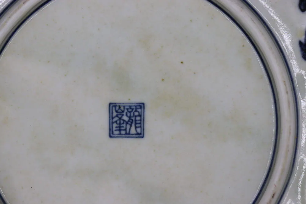 Close-up of the square reign mark in underglaze blue on the plate's base, with faint spotting on the glaze