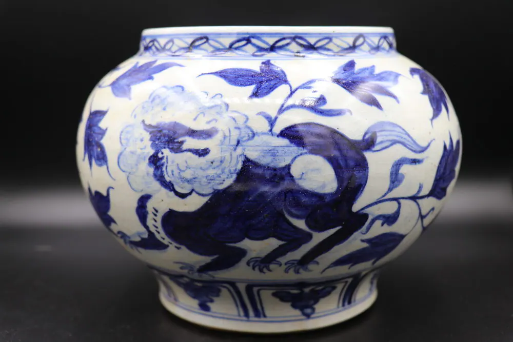 Front view of the blue and white jar showing a lion amid peony blossoms and scrolling leaves