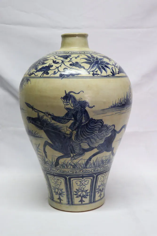 Front view of the blue and white vase showing a warrior on horseback with a raised spear, against a plain backdrop