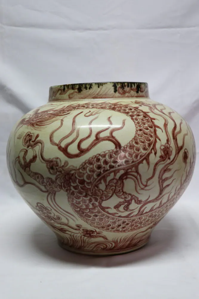 Front view of the copper-red jar with a three-clawed dragon coiling amid flame and cloud scrolls