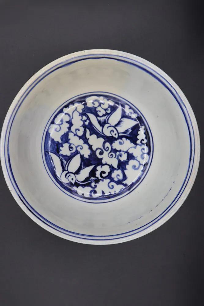 Interior of the bowl with a medallion of white birds among clouds on a blue ground