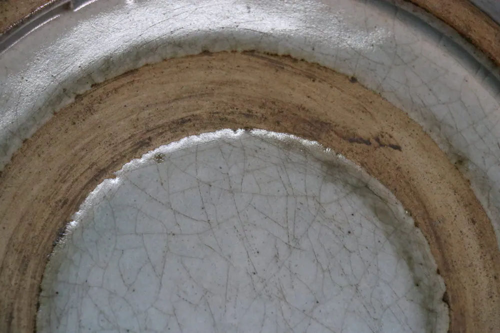 Close-up of the plate's base showing concentric unglazed rings and crazed glaze