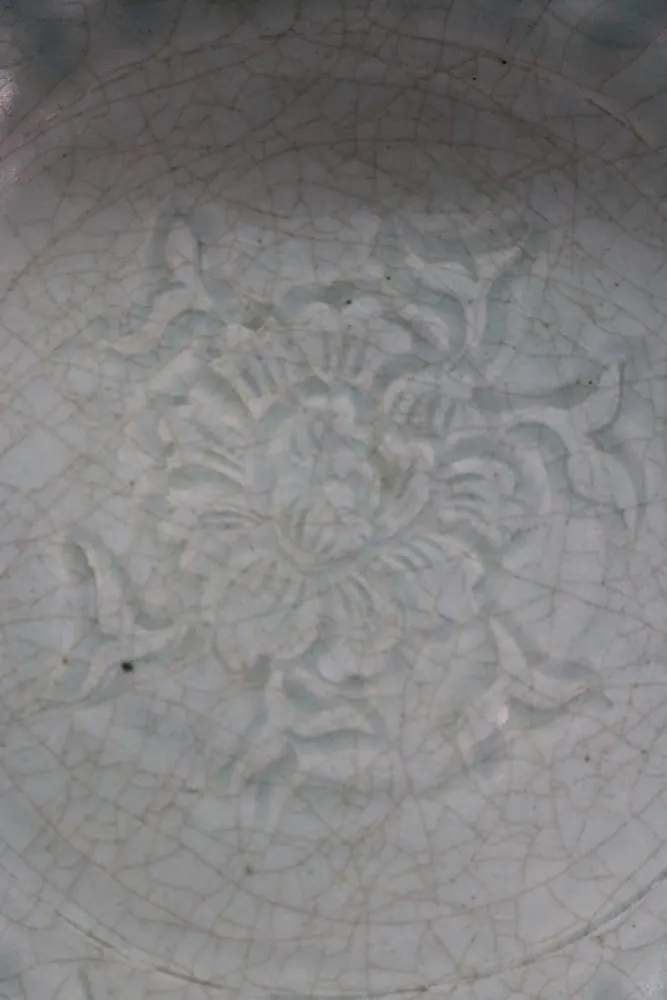 Close-up of the moulded floral medallion on the interior of the celadon plate