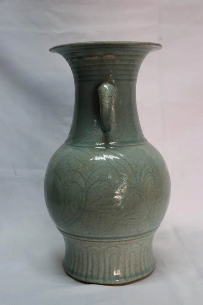 Three-quarter view of the celadon vase showing a ring handle and moulded leaf decoration