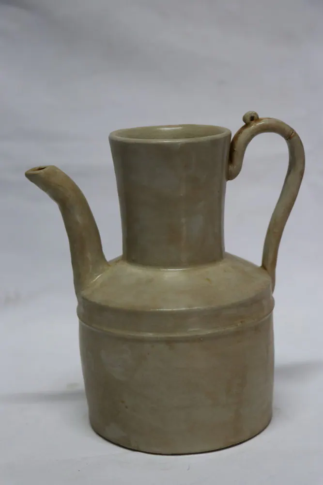 Song ewer with a pale glaze, a tall cylindrical neck, curved loop handle and slender spout on a ribbed body