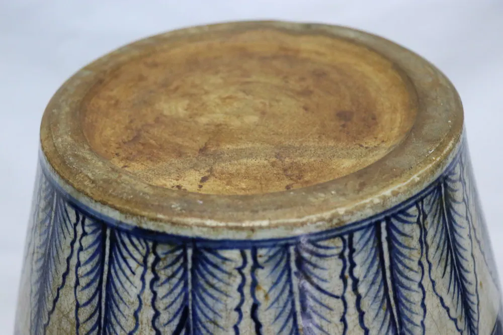 Base of the jar showing the unglazed foot above a border of pointed leaf lappets