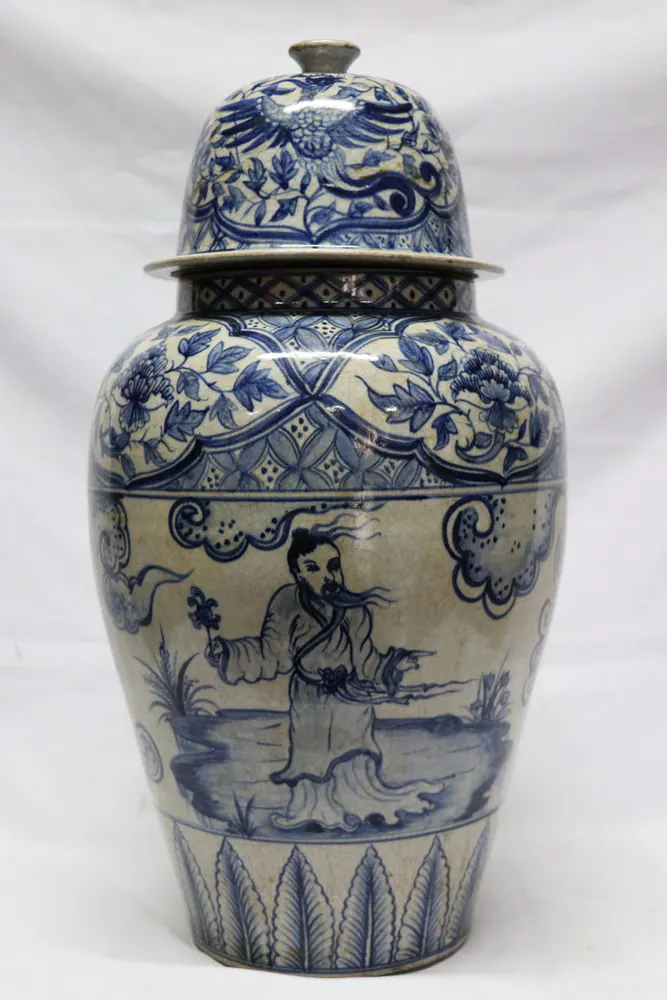 Blue and white covered jar with a domed lid and a scene of a bearded scholar beside a garden pond