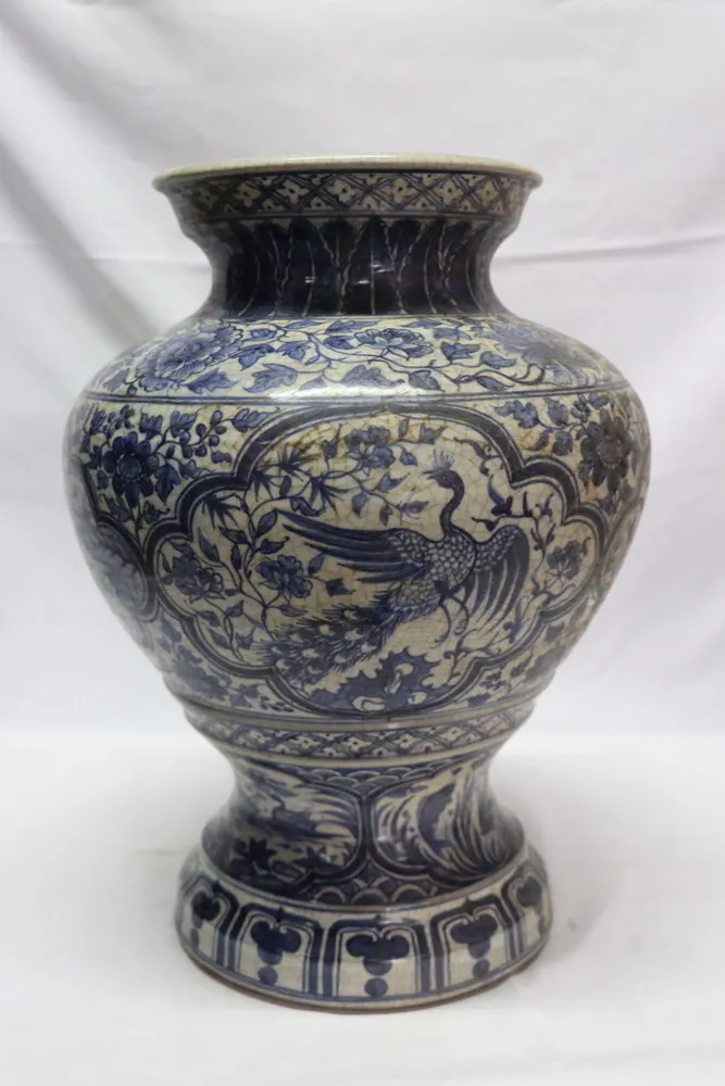 Front view of a waisted baluster vase with a crane medallion above a wave band and lotus panels at the foot