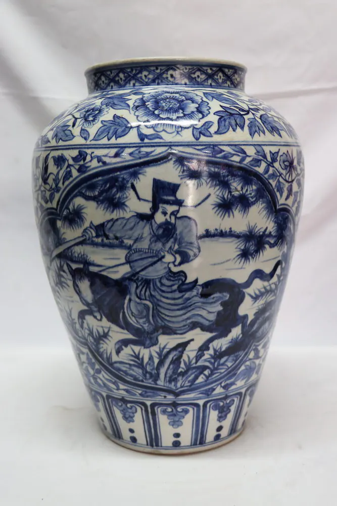 Front view of the vase with a mounted archer riding past pine trees, floral band above