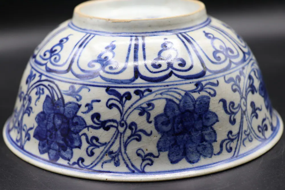 Angled close-up of the ruyi lappet border above lotus scrollwork near the foot