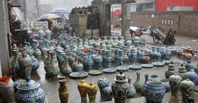 雨中户外市集,湿地上陈列着一排排瓷瓶与瓷罐