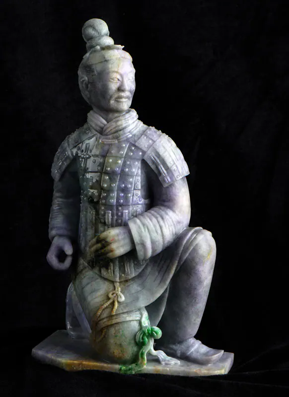 淡紫与绿色玉雕跪姿披甲士兵像,背景为黑色
