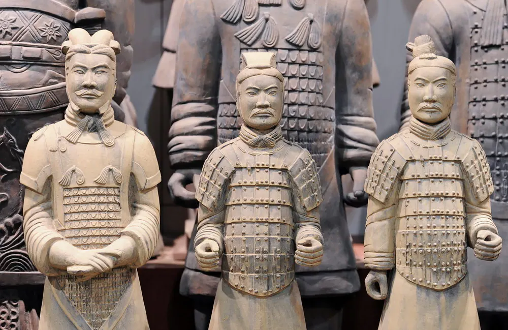 三尊披甲的仿兵马俑式武士像,站在较大的俑像之前