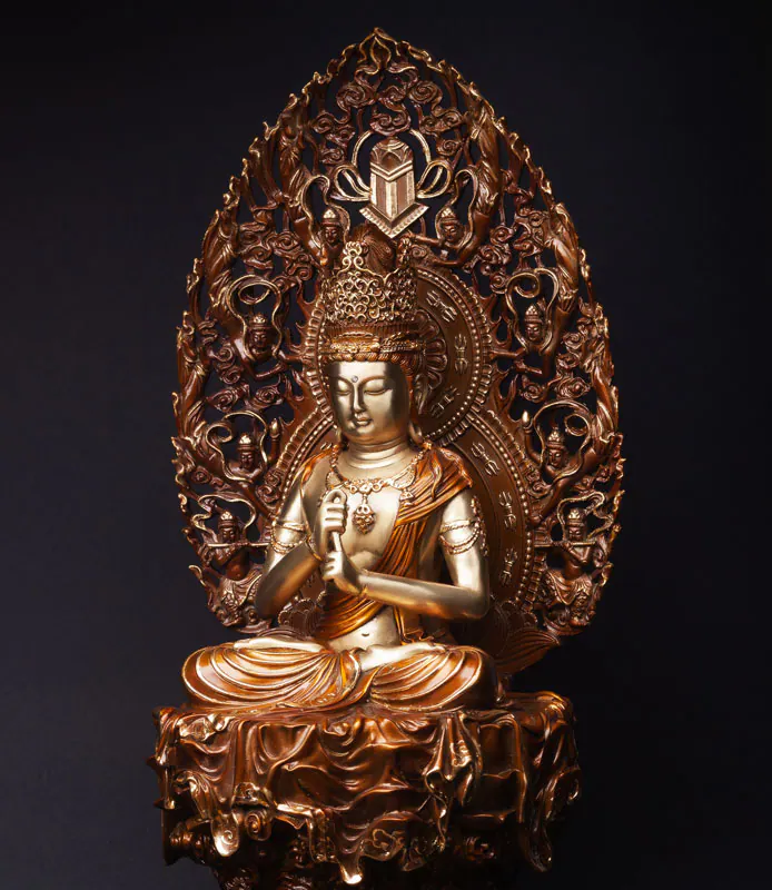 Gilded figure of a crowned Buddhist deity seated in meditation before an openwork flaming halo