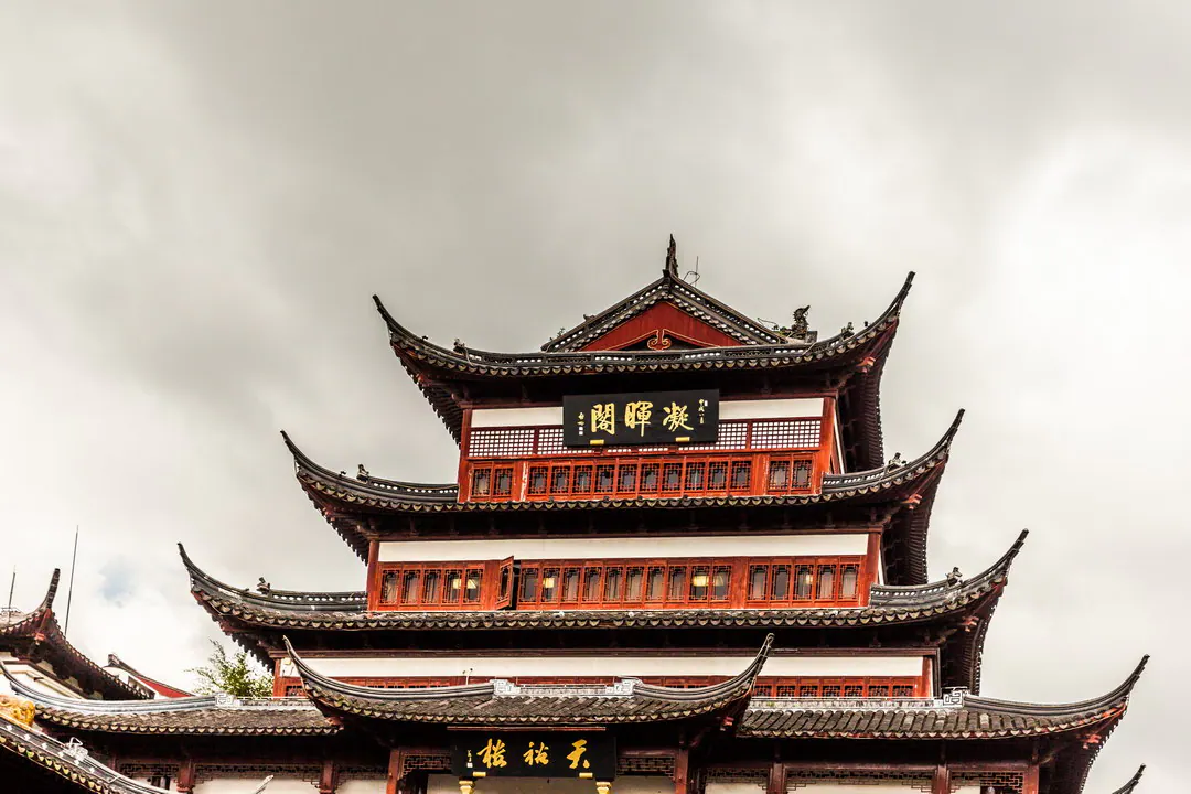 灰色天空下的多层楼阁，飞檐上翘，匾额金字题“凝晖阁”