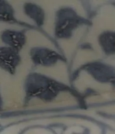Close-up of blue leaf sprays on a crackled glaze, with brown staining in the crackle