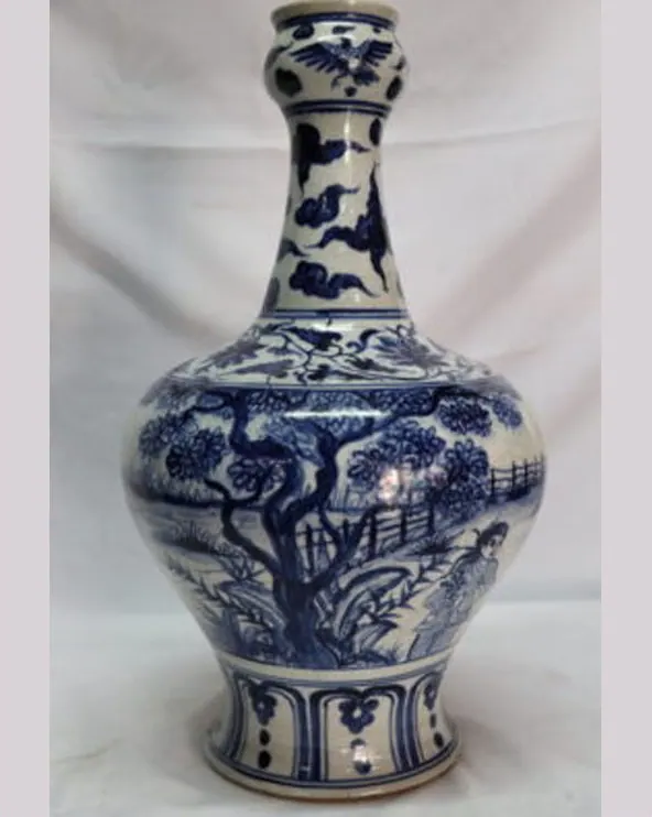 Front view of a blue and white bottle vase with a figure beside a gnarled tree and fence
