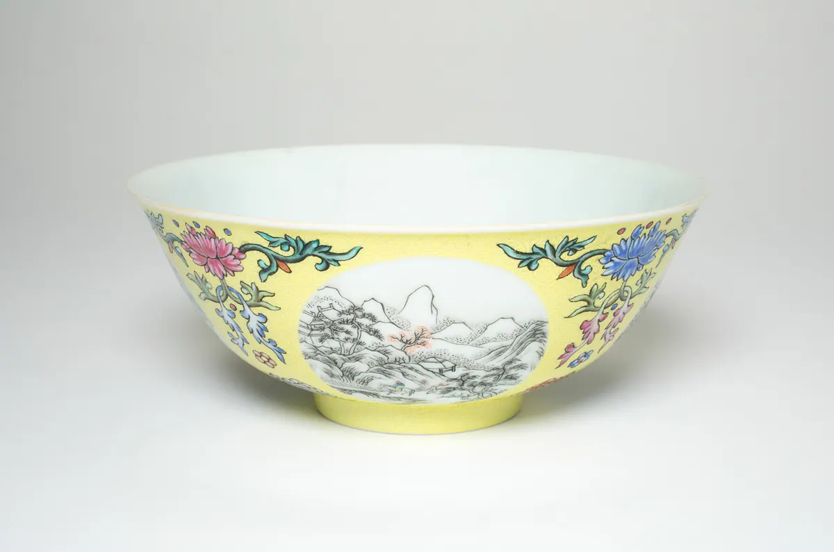 道光瓷碗，黄地绘粉彩与蓝彩花卉纹，环绕白色开光，开光内以灰彩绘山水。