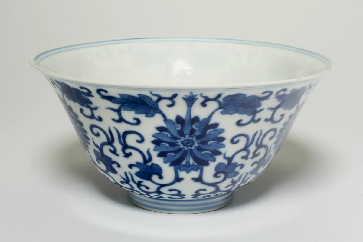 Guangxu blue and white porcelain bowl with flared sides, painted in underglaze cobalt with large stylised flowers on scrolling leafy stems, with blue lines at the rim and foot