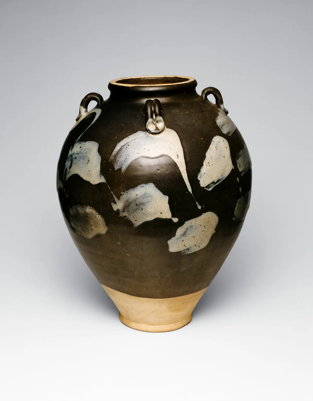 An ovoid Lushan ware stoneware jar with four small loop handles, its dark brown glaze splashed with patches of milky bluish-white, the lower body left bare.
