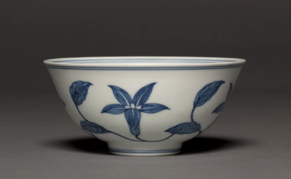 Chenghua mark and period blue and white bowl painted with a scroll of lilies and leaves in a soft, even blue on a clean white ground, with double blue lines at the rim and foot.