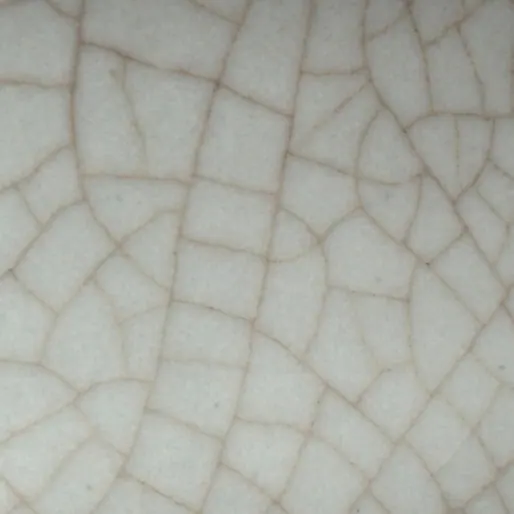 Close-up of the glaze on a Southern Song Guan incense burner, about 3 cm across: a thick grey glaze divided by a bold, widely spaced network of brown crackle