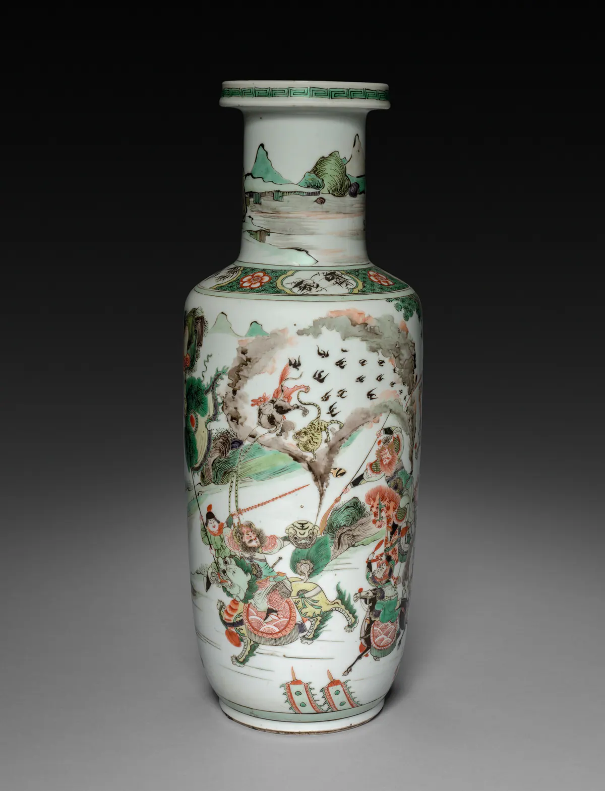 A Kangxi rouleau vase in famille verte enamels, with a straight cylindrical body, a flat angled shoulder and a straight neck, painted with mounted warriors in battle on the body and a landscape on the neck.