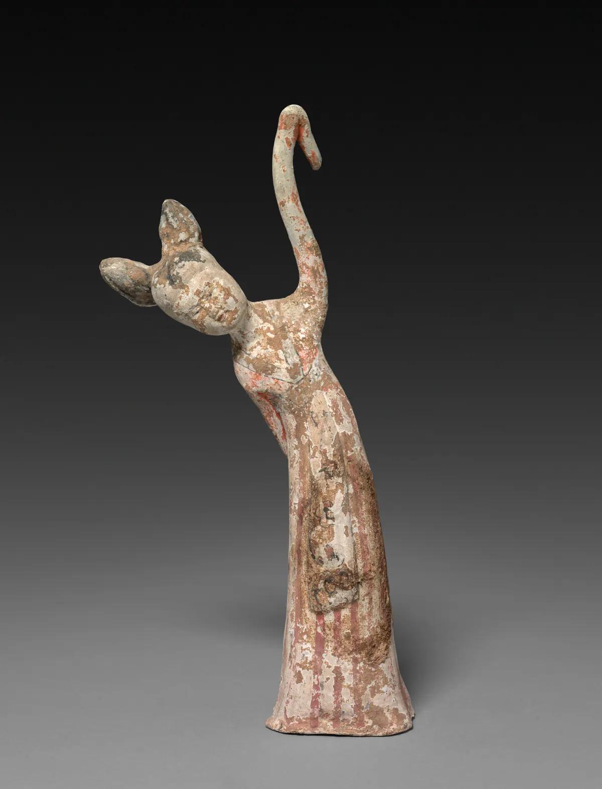 Painted earthenware tomb figure of a female dancer bending to one side with a long sleeve swung up over her head, with worn red and white pigment on a striped skirt.