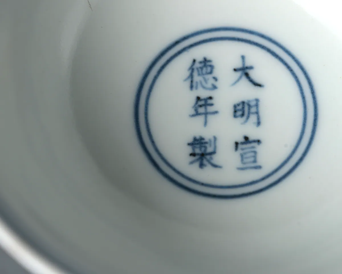 The six-character mark Da Ming Xuande nian zhi in underglaze blue, written in two columns within a double ring inside a Xuande mark and period stem cup