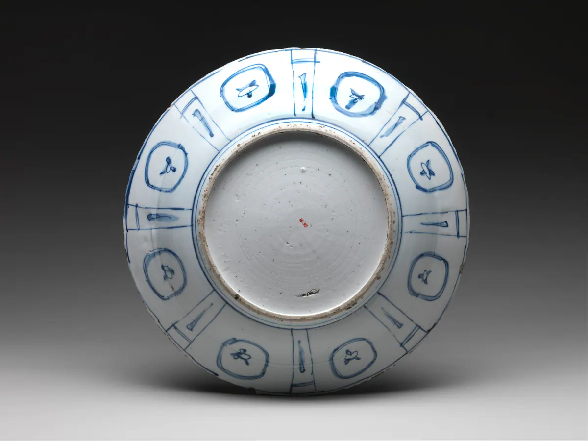 Underside of the same Wanli period kraak dish, showing sketchy panels painted in a few blue strokes, a glazed base with turning marks and kiln grit on the foot ring.