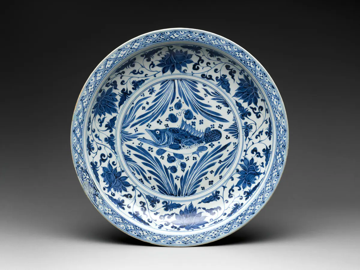 A large Yuan blue and white plate painted with a fish among water weeds in the centre, a lotus scroll in the well and a lattice border at the rim.